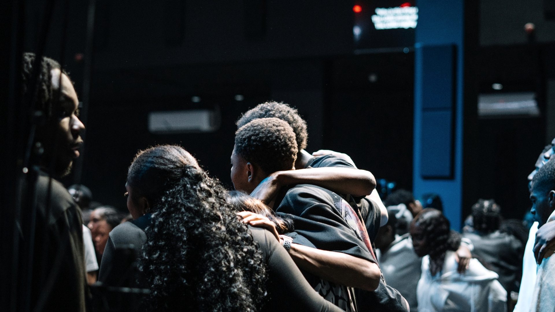A small group embracing in the room after the service.
