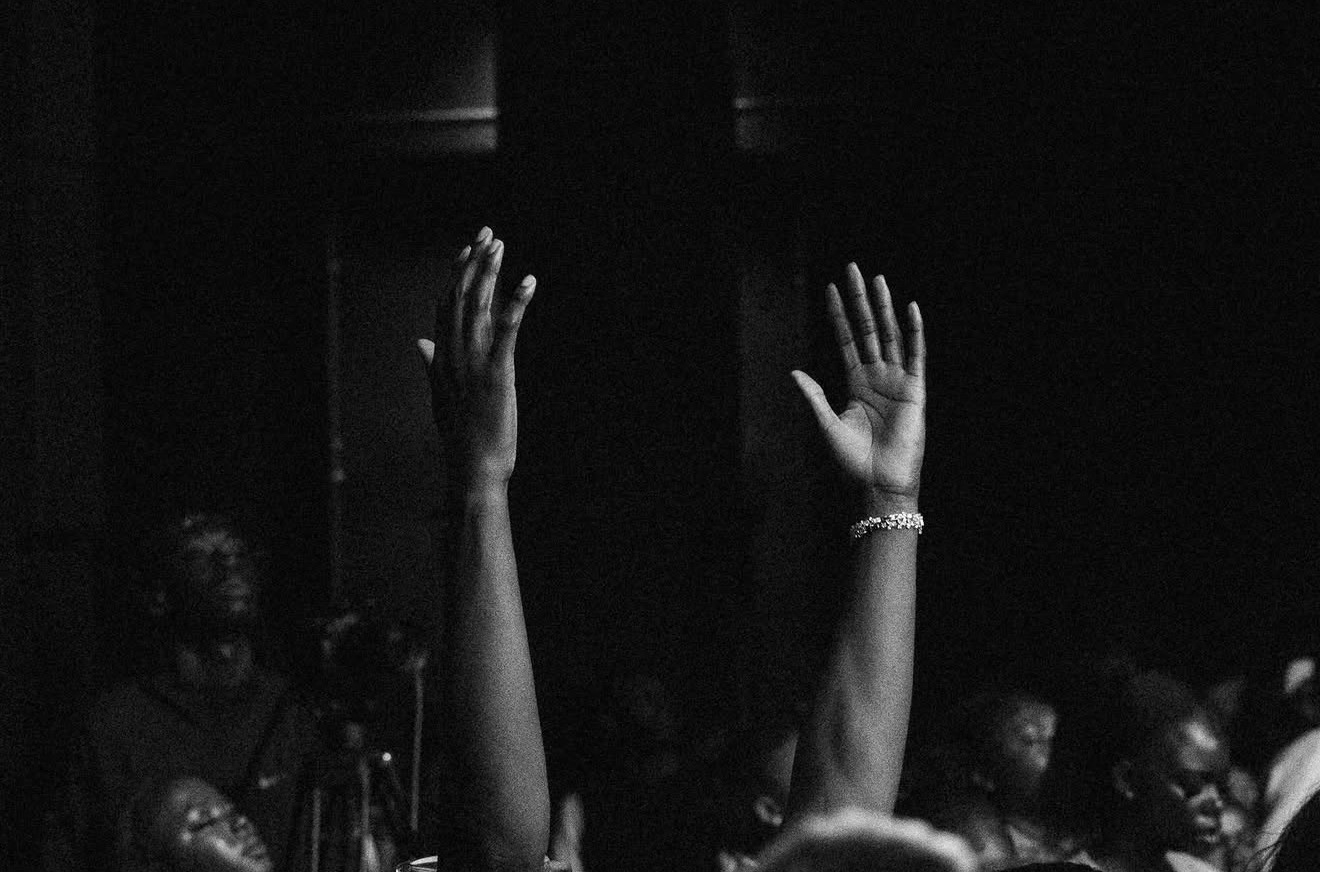 Hands raised in worship at a Sunday gathering
